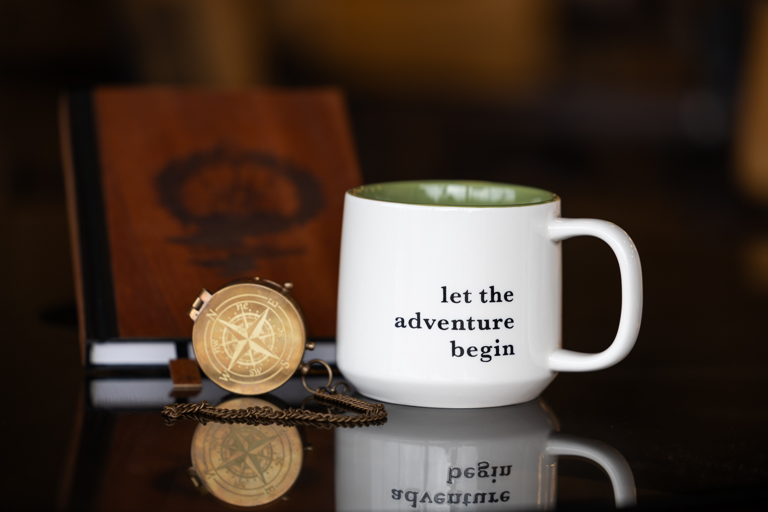 Let the adventure begin coffee cup with a compass and notebook. Compass Communications LLC